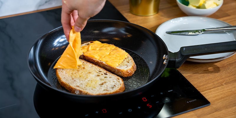 Coloca Una De Las Rebanadas En La Sartén, Con La Mantequilla Normal Hacia Abajo. Pon Las Lonchas De Queso Encima Del Pan